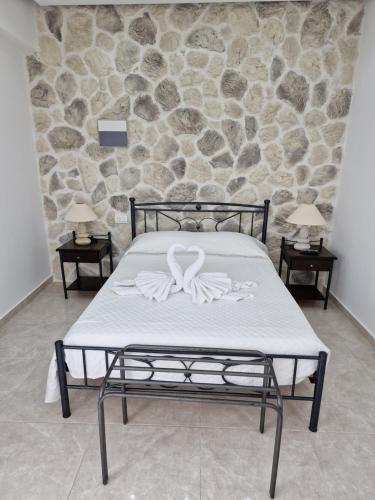 a bed in a room with a stone wall at Stavros Villas in Karterados