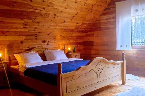 - une chambre avec un lit dans une cabane en rondins dans l'établissement Uroczy drewniany dom w ciszy i spokoju, à Redułty