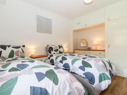 a bedroom with two beds and a mirror at Lilyrose Cottage in Pevensey