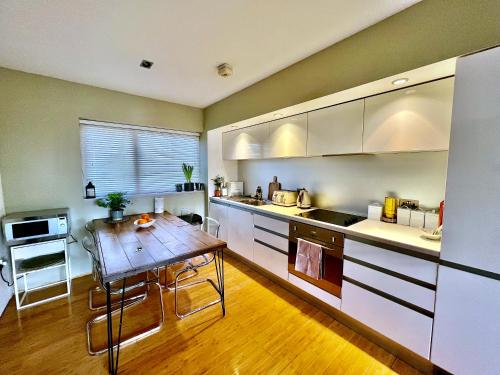 uma cozinha com uma mesa de madeira e um piso de madeira em Zen life with Urban Views - E8 Chic em Londres