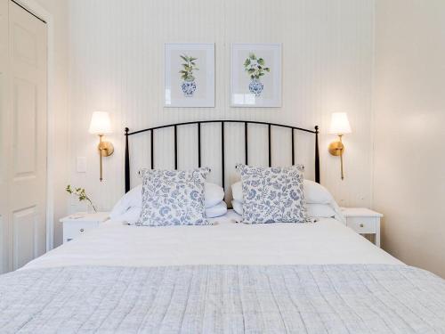 a bedroom with a white bed with blue and white pillows at Waldburg Cottage in Savannah