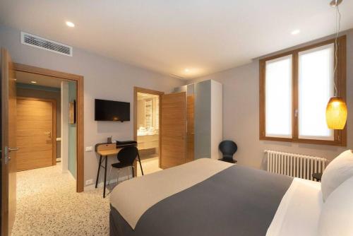 una camera d'albergo con letto e scrivania di Casa del Carro 1 Grand Master Apartment a Venezia