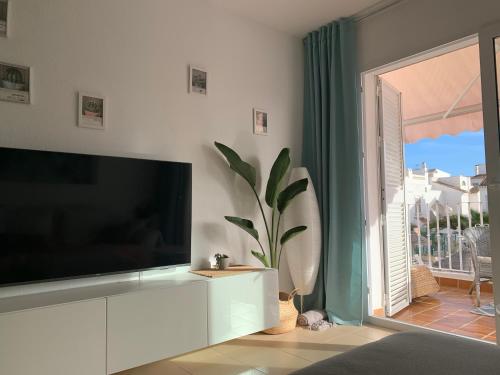 Televízia a/alebo spoločenská miestnosť v ubytovaní Vera Playa La Medina