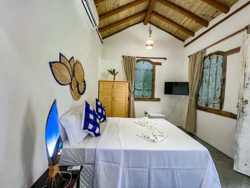 1 dormitorio con 1 cama con mantel blanco en Pousada Casa Sítio Delícia do Quadrado, en Porto Seguro