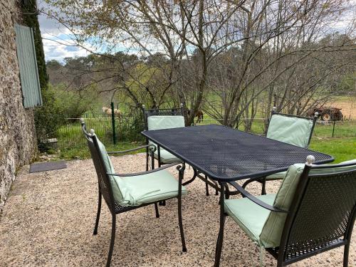 a black table and chairs sitting on a patio at Chambres d’hôtes de Pouzatel in Fumel