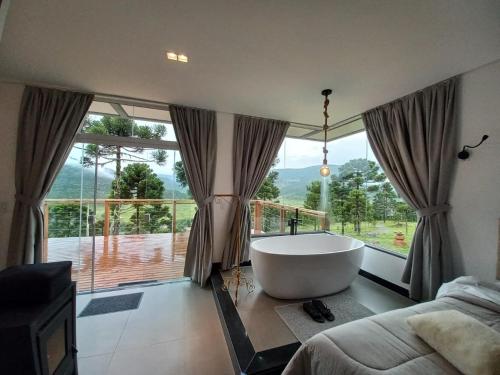 a large bathroom with a tub and a large window at ALTITUDE MÁXIMA - Cabanas de Altitude in Urubici