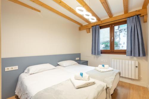 a bedroom with two beds and a window at Gamarra - baskeyrentals in Lekeitio