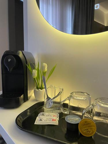 a bathroom sink with a vase of flowers on a counter at Swiss Plus Hotel in Bihać