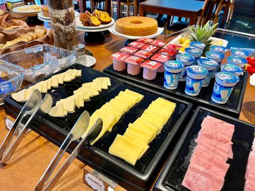a buffet with cheese and other foods and drinks at ibis Styles Presidente Prudente Portal D'Oeste in Presidente Prudente