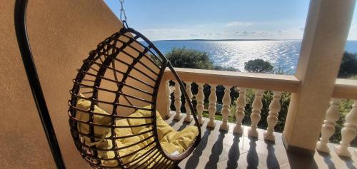 a swing on a balcony with a view of the ocean at Comfortable family apt Iris 20m from beach in Mandre in Mandre
