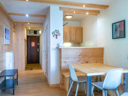 une cuisine et une salle à manger avec une table et des chaises en bois dans l'établissement Élégant 3 pièces rénové avec balcon, cœur de Val-d'Isère, proche commodités - FR-1-694-1, à Val dʼIsère