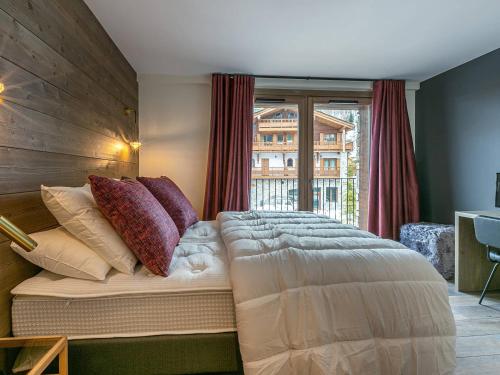 a bedroom with a bed with pillows and a window at Appartement Val-d'Isère, 5 pièces, 8 personnes - FR-1-694-4 in Val-d'Isère