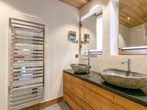 une salle de bain avec deux lavabos sur un comptoir dans l'établissement Appartement de luxe avec cheminée, balcon et services inclus, au pied de la forêt de Bellevarde - FR-1-694-12, à Val dʼIsère