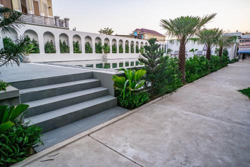 a staircase leading to a building with palm trees at Emerald Residence Kampot in Kampot