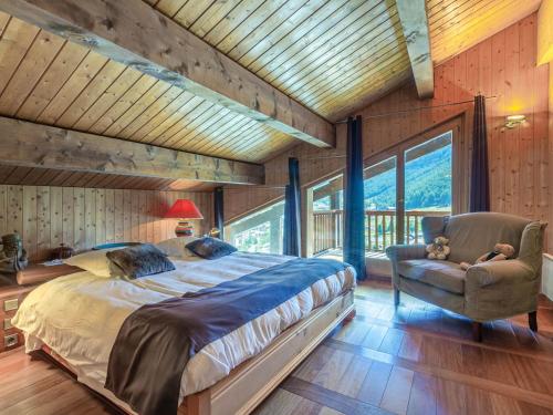 une chambre avec un grand lit et une chaise dans l'établissement Chalet de luxe avec sauna, cheminée et WiFi à Val-d'Isère - FR-1-694-17, à Val dʼIsère