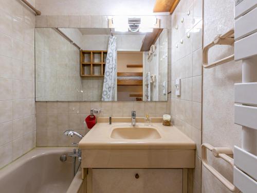 une salle de bain avec un lavabo et une baignoire dans l'établissement Studio cosy avec balcon, parking couvert, proche centre et navette gratuite – Val d'Isère - FR-1-694-59, à Val dʼIsère
