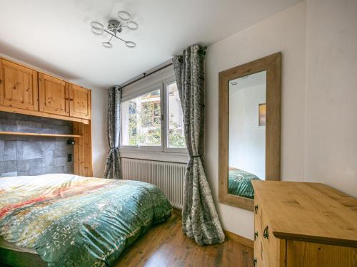 une chambre avec un lit, un miroir et une fenêtre dans l'établissement Charmant Appartement Confortable avec Wifi, Navette Gratuite pour les Pistes, à Val-d'Isère - FR-1-694-49, à Val dʼIsère