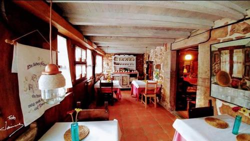 una habitación con mesas y sillas en un edificio en Casa Rural La Posada del Alba, en Alea