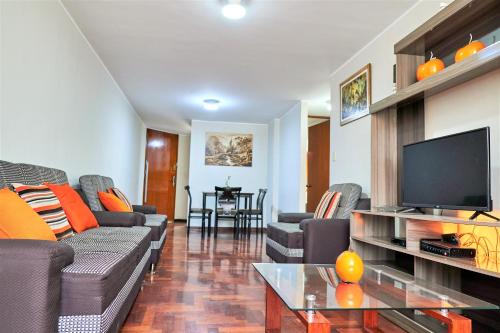 sala de estar con sofás y TV de pantalla plana. en Eral Apartments Santa Catalina, en Lima