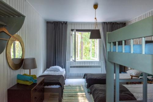 a bedroom with two bunk beds and a window at Saarjärve Puhkemaja 16-le 4 magamistuba in Tromsi