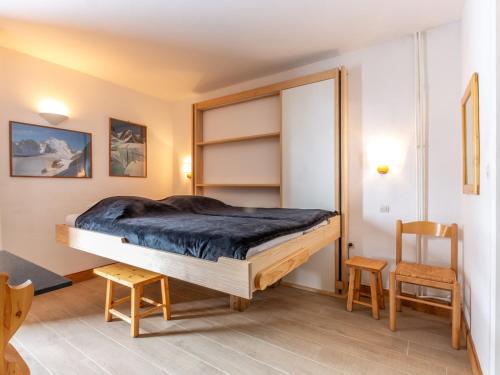 Un dormitorio con una cama grande y dos sillas. en Studio cosy au cœur de Val-d'Isère, pieds des pistes, accès wifi, 2 pers. - FR-1-694-74, en Val dʼIsère