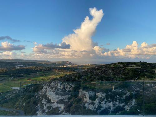 a view of a mountain with a blue sky and clouds at A52 - Apartment with Sea and Country Views in Mellieħa