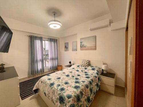 ein Schlafzimmer mit einem Bett mit einer blauen und weißen Decke in der Unterkunft Boca Chica Luxury apartment in Boca Chica