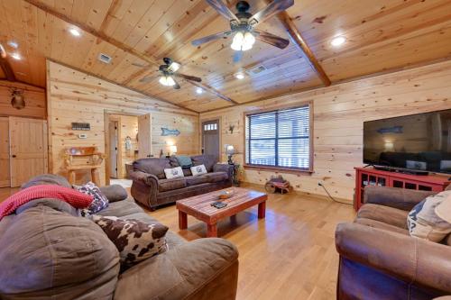 a living room with couches and a flat screen tv at Broken Bow Cabin with Hot Tub and Covered Deck! in Stephens Gap