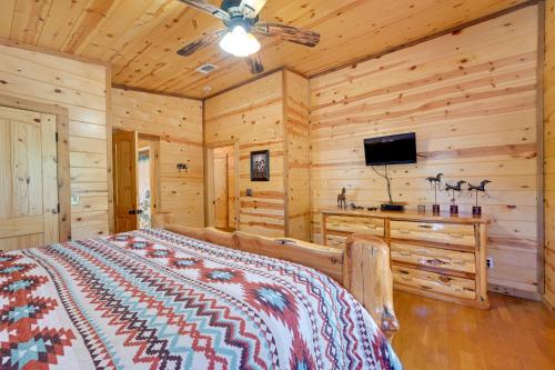 a bedroom with a bed and a flat screen tv at Broken Bow Cabin with Hot Tub and Covered Deck! in Stephens Gap