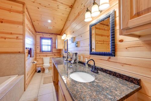 a log cabin bathroom with a sink and a toilet at Broken Bow Cabin with Hot Tub and Covered Deck! in Stephens Gap