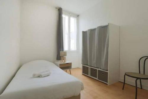 a bedroom with a bed and a tv and a chair at Point calme & stratégique de Tours in Tours