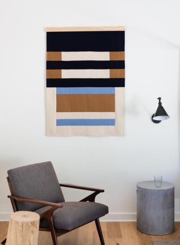 a chair and a table in a room with a painting at Contigo Ranch Fredericksburg in Fredericksburg