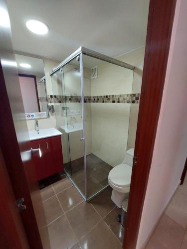 a bathroom with a toilet and a glass shower at Hotel Cabrera Real in Bogotá