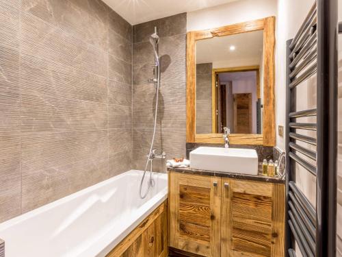 a bathroom with a tub and a sink and a mirror at Appartement luxe avec wifi et parking sur les pistes au cœur de Val-d'Isère - FR-1-694-133 in Val dʼIsère