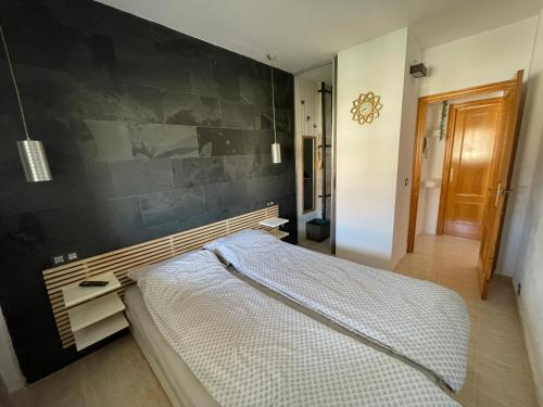 a bedroom with a bed with a black wall at Modern Apartman - Novamar 1 in Gran Alacant