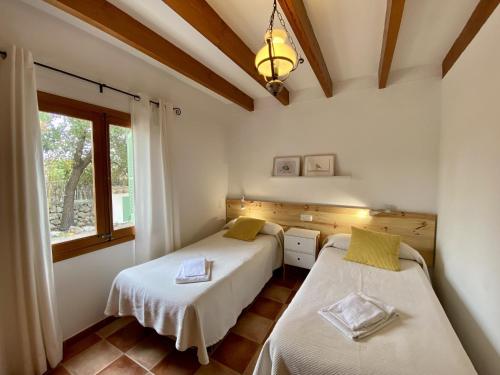 two beds in a room with a window at Encant in Pollença