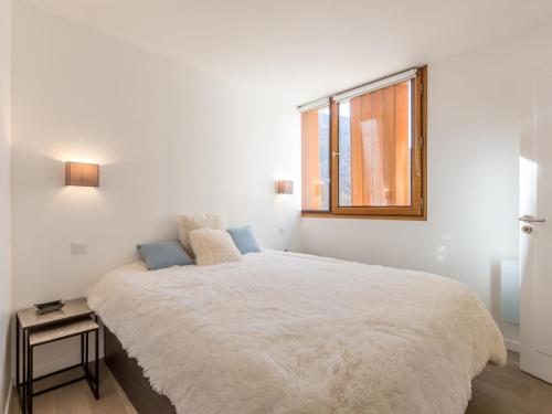 a bedroom with a large white bed with a window at Appartement élégant contemporain avec balcon sud et wifi - FR-1-694-170 in Val dʼIsère