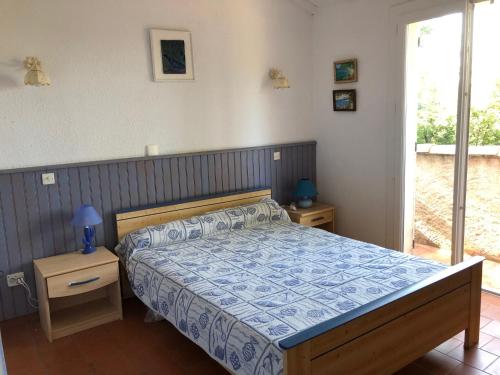 une chambre avec un lit avec une couette bleue dans l'établissement Villa Kikouyou, au Lavandou