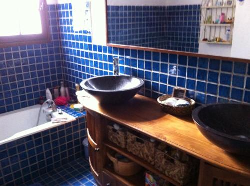 une salle de bain carrelée bleue avec deux lavabos et une baignoire dans l'établissement Villa Kikouyou, au Lavandou