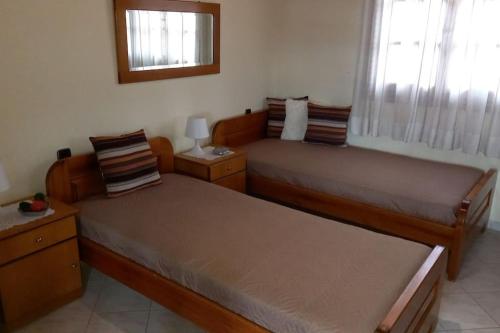 a bedroom with two beds and a mirror at Giannis Traditional House in Vamos