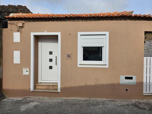 a house with a white door and a window at Curtido House Suits in Ílhavo