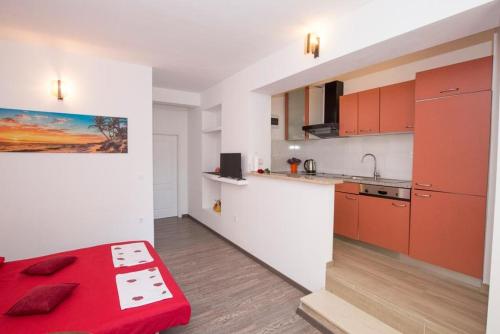 a kitchen with red cabinets and a red bench in a room at Apartment in Duce with terrace, air conditioning, WiFi, dishwasher 5146-8 in Duće