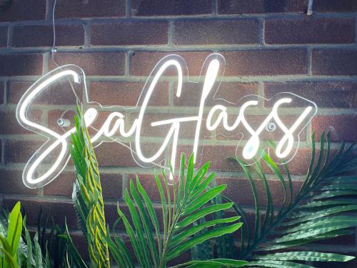 a neon sign that says artacs on a brick wall at Sea Glass Cottage - Hotel style 3 bed optional hot tub in Seaham