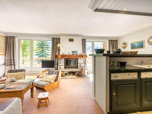 une cuisine et un salon avec un canapé et une table dans l'établissement Appartement de standing avec cheminée et parking en haut des pistes - FR-1-694-247, à Val dʼIsère