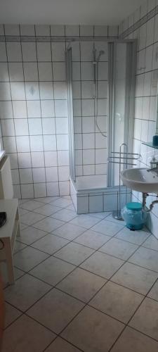 Ruhland的住宿－Pension Sorrento，带淋浴、桌子和浴缸的浴室