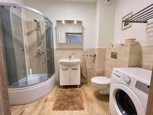 a bathroom with a sink toilet and a washing machine at Nowoczesny apartament blisko centrum Warszawy z podziemnym garażem i bardzo szybkim WiFi oraz balkon in Ząbki