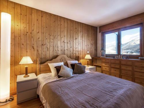 - une chambre avec des murs en bois et un lit avec deux lampes dans l'établissement Chalet semi-indépendant avec terrasse et WiFi à Val-d'Isère - FR-1-694-267, à Val dʼIsère