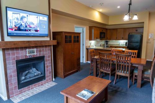 a living room with a fireplace with a television above it at The Appalachian at Mountain Creek in Vernon