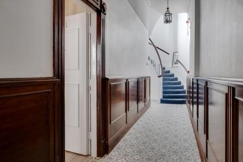 a hallway with a stairway with blue stairs at Rodney Street Luxury Townhouse & Apartments, Central & Stylish in Liverpool