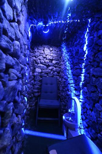 a bathroom with a toilet in a stone building with lights at H49 Apartman Wellness & Spa - Adults only in Sovata